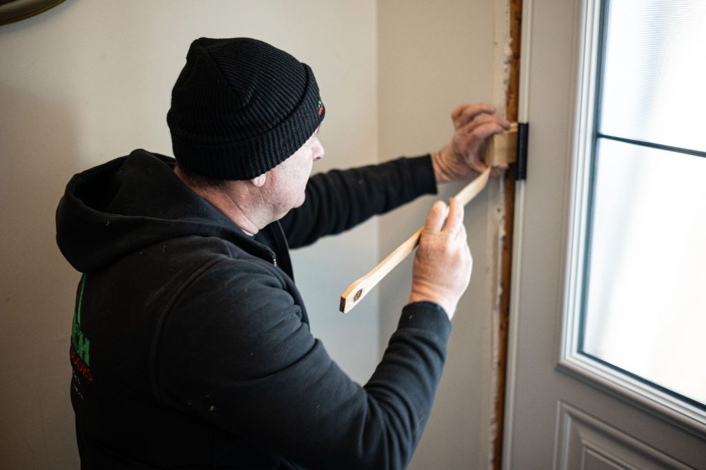 Using shims to balance out a new entry door installation.