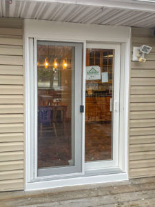 White patio door with attached screen bringing natural light and outdoor views