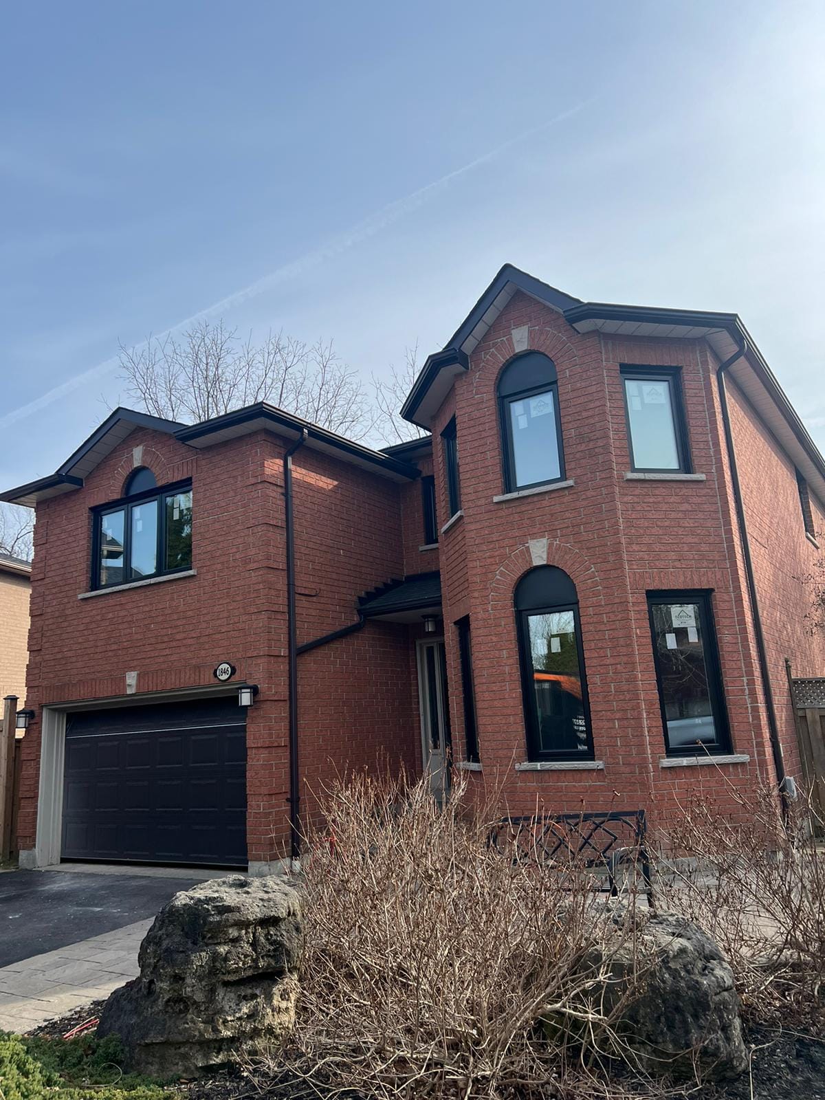 Exterior view of a red brick house featuring energy-efficient design elements, including insulated windows