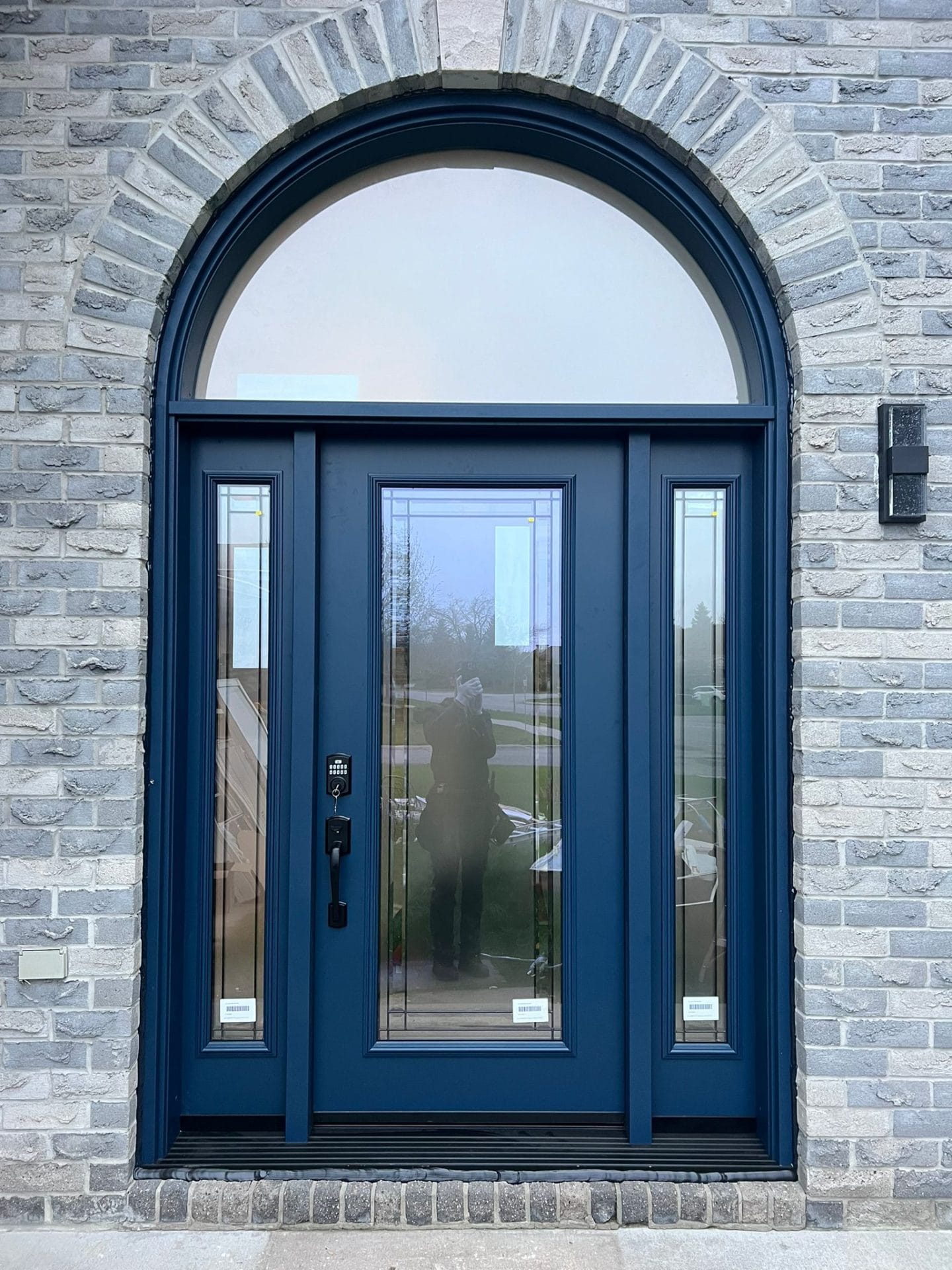 A blue door with privacy glass for natural light on sides and Top for the best windows and doors company