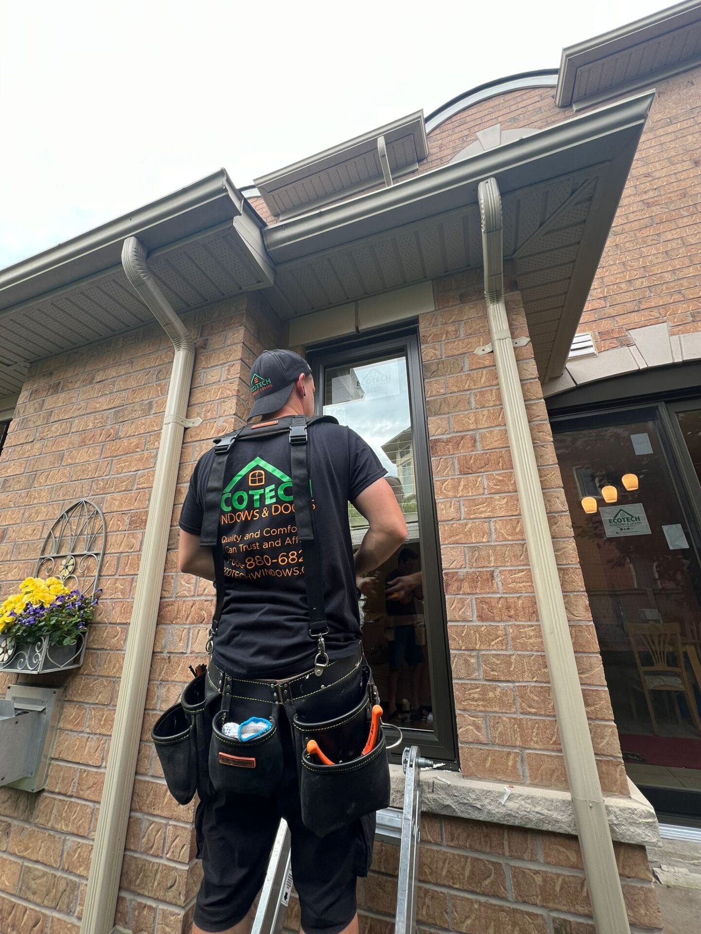 Alt text for an installer putting in EcoTech windows:An installer from EcoTech Windows and Doors carefully installing a window, ensuring precision and quality.