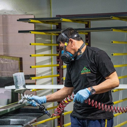 Painting a slab at the EcoTech entry door manufacturing facility.