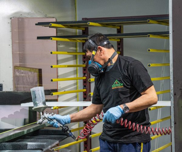 Painting a slab at the EcoTech entry door manufacturing facility.