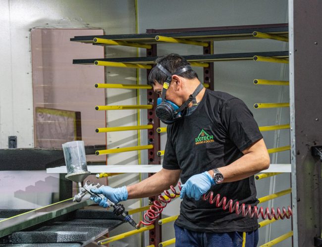 Painting a slab at the EcoTech entry door manufacturing facility.